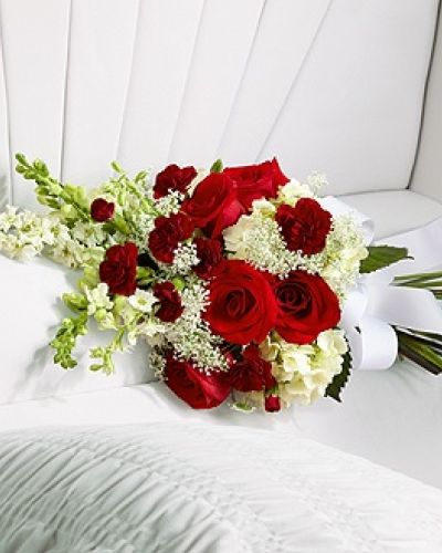 The FTD&reg; Forever in Our Hearts&trade; Casket Adornment is a beautiful accent piece that adds that extra touch of elegance to their final farewell service. Red roses and mini carnations are eye-catching and bright arranged amongst white hydrangea, larkspur, snapdragons and Queen Anne's Lace. Tied together with a white grosgrain ribbon, this gorgeous bouquet is a lovely way to say goodbye to your beloved.