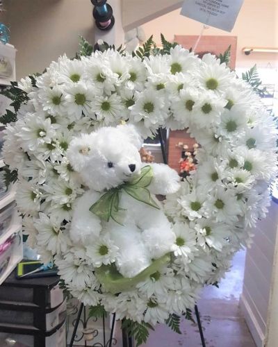 Send love and hugs with this sweet wreath featuring a keepsake plush. From welcoming a new baby to care and concern, this thoughtful arrangement will speak volumes when words may fail.