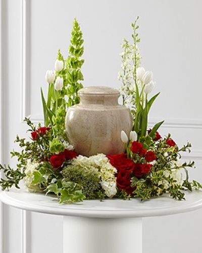 The FTD&reg; Tears of Comfort&trade; Arrangement is an elegant and sophisticated way to surround their urn with floral beauty at the final farewell service. Rich red roses and spray roses are vivid and bright arranged amongst white tulips, larkspur, hydrangea, and trachelium, accented with the bright greens of Bells of Ireland, hypericum berries, ivy and myrtle, creating a wonderful way to honor the life of the deceased.