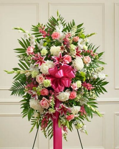 Convey your deepest sympathies and continued support with this vibrant standing spray. Expertly crafted from an assortment of pastel blooms such as roses, lilies, mums, gladiolas, snapdragons, Bells of Ireland, carnations, heather and more, it's a comforting way to let them know that you're thinking of them during this difficult time. Appropriate for family, friends or business associates to send directly to the funeral home.