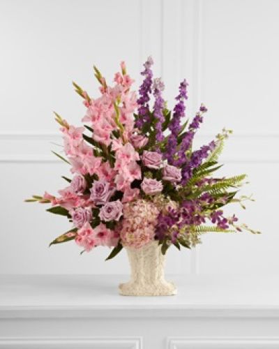 The FTD® Flowing Garden™ Arrangement bursts with a bounty of blooms to create a stunning tribute of the deceased at their final farewell service. Lavender roses, pink gladiolus, purple dendrobium orchids, purple larkspur and pink hydrangea are accented with an assortment of lush, vibrant greens and perfectly arranged in a papier mache urn to create a presentation of grand beauty that symbolizes the life of the departed.
