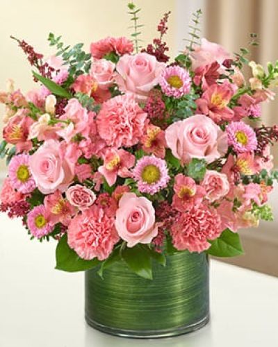 <p>Send a gift of lasting tribute to loved ones who have passed on. Our color-soaked, all-pink arrangement features pink roses, spray roses, snapdragons, alstroemeria, carnations, asters and heather gathered with variegated pittosporum, salal and spiral eucalyptus in a stylish clear glass cylinder vase wrapped with a Ti leaf ribbon.</p>