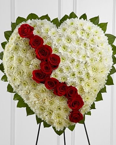 The FTD&reg; Broken Heart&trade; is a beautiful way to express the impact that the departed had on your life. Pearly white chrsyanthemums form the shape of a heart, accented with greens lined around the outside and "broken" in the middle with a line of rich red roses to create an exqusite way to honor the life of the deceased at their memorial service. Displayed on a wire easel.