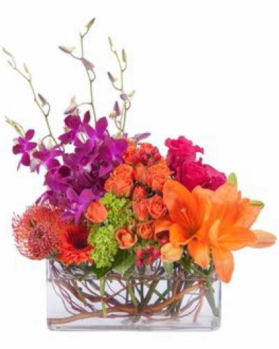 <p>Bright and cheery, this colorful display of premium blooms are artfully arranged in a clear glass container.</p>