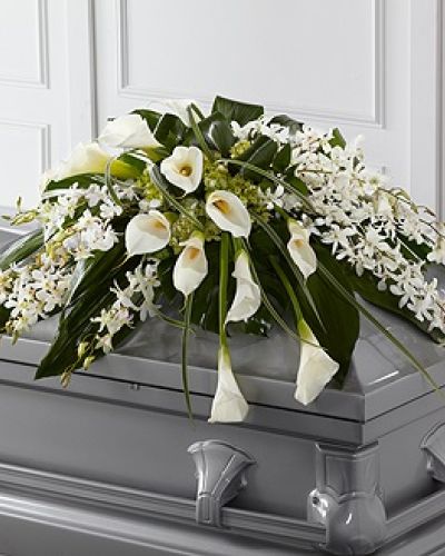 The FTD&reg; Angel Wings&trade; Casket Spray is an exceptionally gorgeous way to bring peace and beauty to their final farewell service. White Dendrobium orchids, white calla lilies, green hydrangea and a variety of lush greens are artfully arranged to perfectly adorn the top of their casket, offering the colors and ambience of grace and serenity.