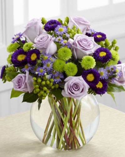 The Splendid Day Bouquet, set with roses and asters, creates the perfect bouquet for any of life's special moments.
Lavender roses, lavender monte casino asters, purple matsumoto asters, green hypericum berries, green button poms and lush greens create a stunning flower bouquet perfectly arranged in a clear glass bubble bowl vase to create a wonderful thank you, happy birthday or congratulations gift.