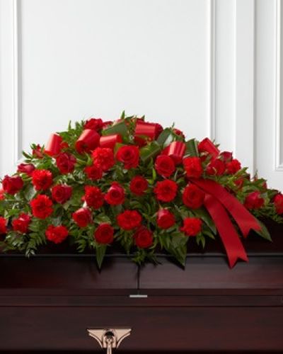 The FTD&reg; Dearly Departed&trade; Casket Spray bursts with the love and passion that the deceased had for their life and loved ones. Rich red roses and carnations are gorgeously arranged amongst lush greens and accented with a red satin ribbon to create the ideal adornment for their casket at their final farewell service.