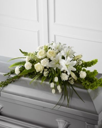 The FTD&reg; Resurrection&trade; Casket Spray inspires thoughts of comfort and peace to those wishing to pay their respects for the loss of the deceased. White tulips, roses, snapdragons, Oriental lilies, larkspur, carnations and monte casino asters are accented by the bright green stems of Bells of Ireland and an assortment of the finest lush greens to create the perfect arrangement to display on the top of their casket during their final farewell service.