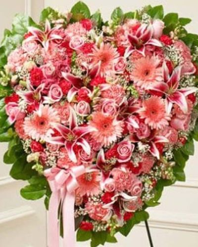 <p>This solid heart standing spray is a beautiful symbol of your sympathy and support. Featuring pink flowers such as roses, stargazer lilies, Gerbera daisies, carnations and more, it is tied to a wire easel with satin ribbon. Traditionally sent directly to the funeral home by family and friends.</p>