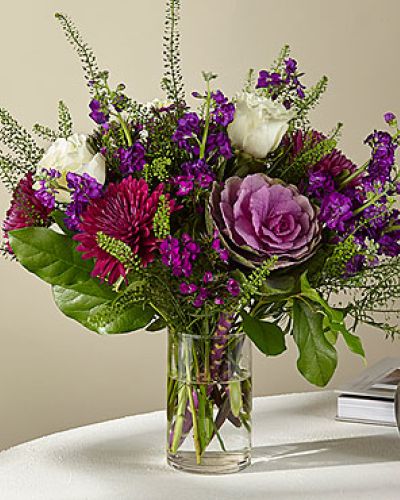 <p>Unbridled enchantment emanates from purple Cremon mums, Sweet William dianthus, spray stock and kale, as well as white roses, ushering in a sense of majesty and magic.</p>